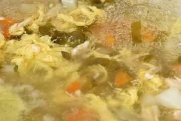 Beautiful and transparent meat broth with vegetables, cooking soup. Close-up