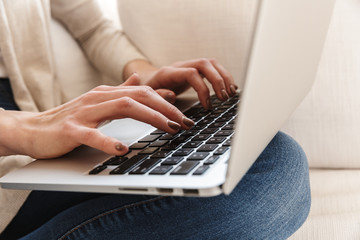 Cropped image of a woman posing sitting using laptop