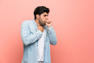 Young man over pink wall is suffering with cough and feeling bad