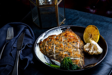 Flounder fillet roasted in a skillet with herbs and lemon