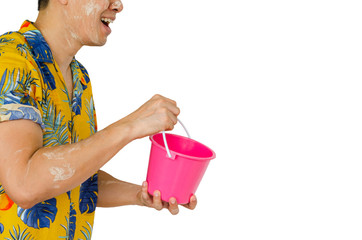 Thai male with white clay filler on face wearing colorful shirt holding bucket for Songkran or Water festival in Thailand concept.