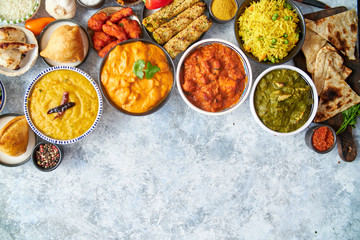 Composition of Indian cuisine in ceramic bowls on stone table