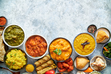 Composition of Indian cuisine in ceramic bowls on stone table