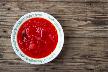 Traditional  ukrainian vegetarian beet red soup - borscht on wooden background. Top view.