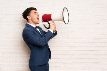 Man in suit and bow tie shouting through a megaphone