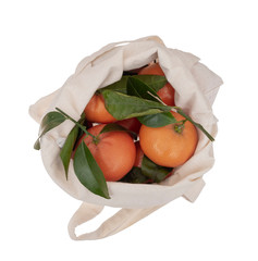 Fresh picked oranges in reusable, recyclable fabric shopping tote bag, isolated on white. For environmentally friendly, green consumers.Overhead view.