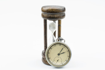 A hourglass and old mechanical watch isolated on a white background.