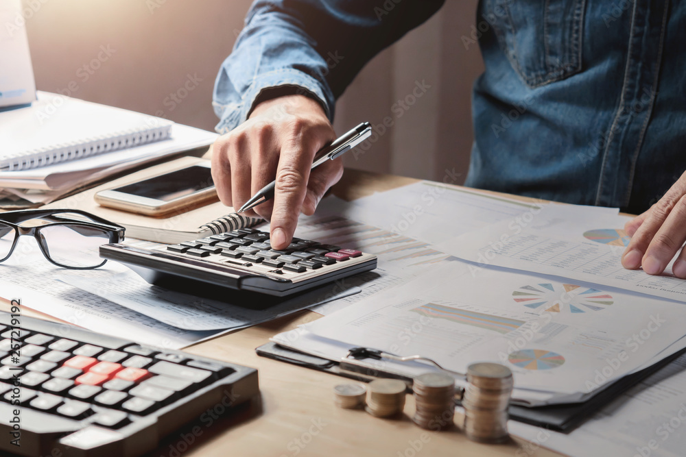 Poster businessman working in office with using a calculator to calculate the numbers finance accounting concept