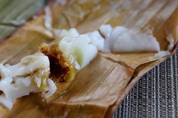 Kanom Sai Sai, Steamed Flour with sweet coconut Filling in banana leaf wrapping, delicious Thai local dessert, high sugar and cholesterol level that may affect health and cause of many diseases