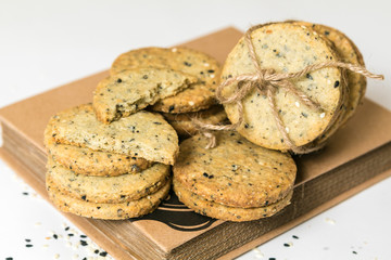 Sesame cookies pile with rustic twine isolated on white background