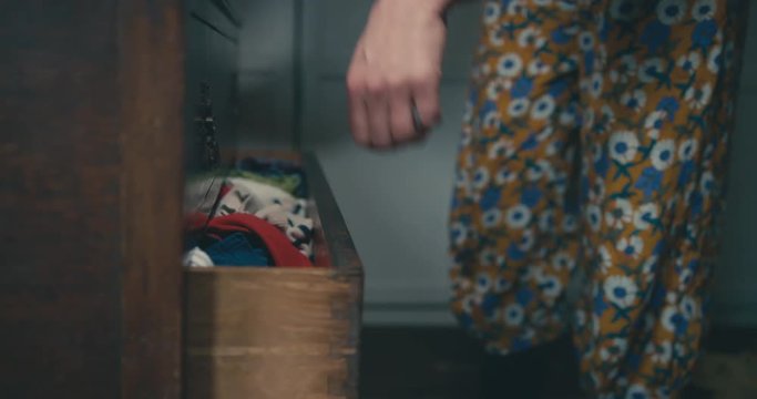 Young mother putting away her toddler's clothes