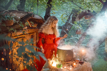 pretty young lady with blond curly hair above big magic cauldron with smoke and bottles with...