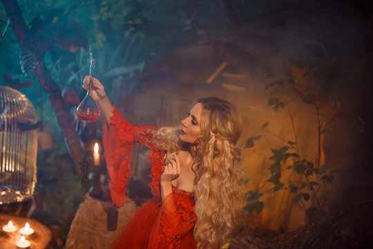 pretty young lady preparing a potion to bewitch her beloved boyfriend, girl with blond curly hair in a long sexy red dress with long sleeves, mysterious forest fairy of love, the daughter of cupid