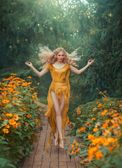 Mysterious attractive flower fairy in light yellow dress with long train and open legs in jump in...