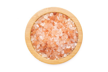 Lot of pieces of pink himalayan salt crystals on bamboo plate flatlay isolated on white background
