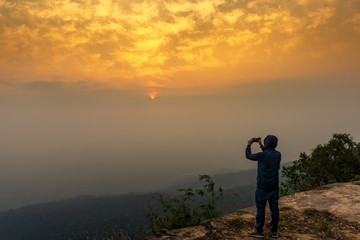Tourist taking picture of sunrise sky nature background
