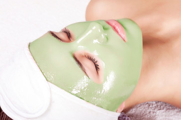 Young beautiful woman with moistening seaweed facial mask at beauty salon. © Vladimir Sazonov