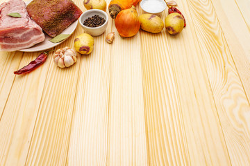Ingredients for meat stew with potatoes and vegetables. Raw pork fillet, brisket, spices on a stone background, copy space.
