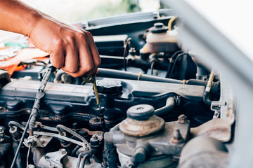 Hand mechanic repairing car  checking level oil
