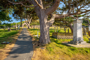 Obraz premium Shaded path through th cemetery of St. Tudno's Church, Llandudno, Wales
