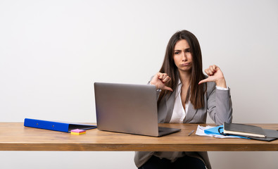 Business woman in a office showing thumb down