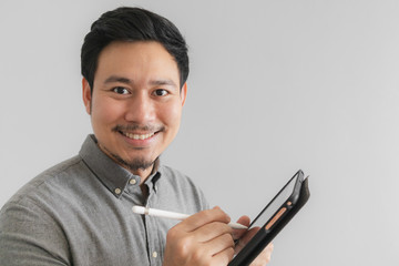 Happy and smile entrepreneur businessman work on his tablet with grey background.