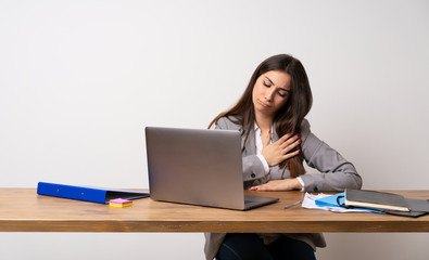 Business woman in a office having a pain in the heart