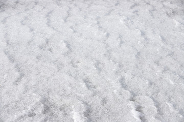 Fototapeta premium Wavy texture of snow with ice crystals on the surface. Beautiful bokeh