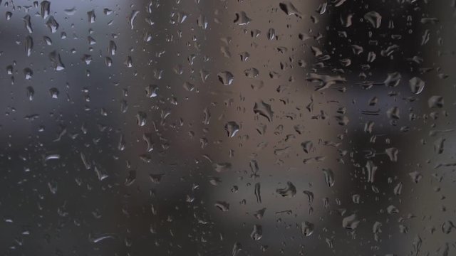 Autumn background, rain drops running down the window.