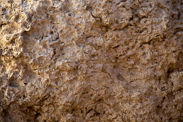 Vintage mud wall in the desert made with beach rocks and coral stones. Texture of stone old wall, old dry coral of brown color. Natural background.