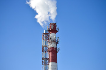 Two pipes. Industrial smoke from a chimney against the sky