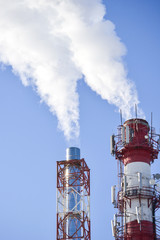 Two pipes. Industrial smoke from a chimney against the sky