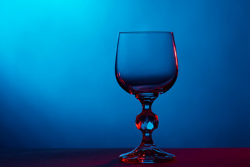 Beautiful wine glass on blue background close up