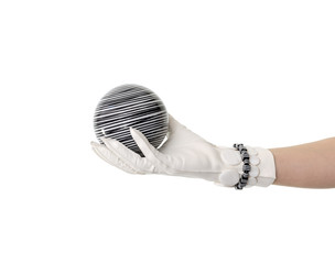 Female hand wearing white glove holding a decorative striped porcelain ball. Isolated on white background.