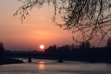 Sunset over the river in the evening city