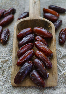 Fresh dates on a wooden old tray lying on the table.