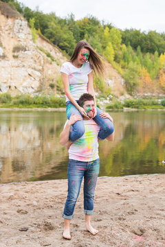 People, tourism and nature concept - Smiling couple with painted faces having fun