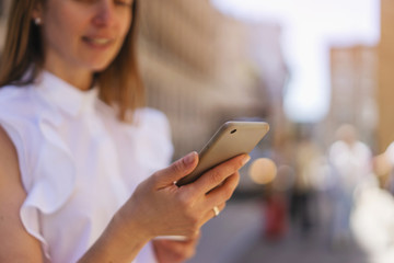 Close up of female hands using smartphone outdoor in sunny day, Happy woman using smartphone device in downtown
