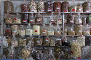 bags of dried ingredients sitting of shelves in a chinese dry food shop
