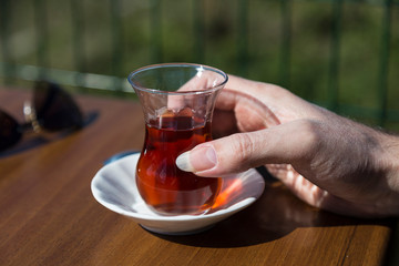 the man hold glass of tea in the hand.