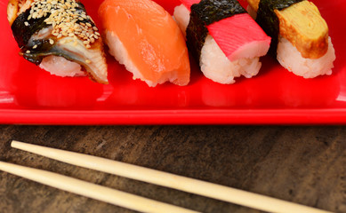 Closeup chopsticks and row of sushi