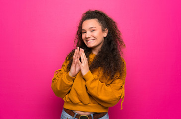 Teenager girl over pink wall scheming something