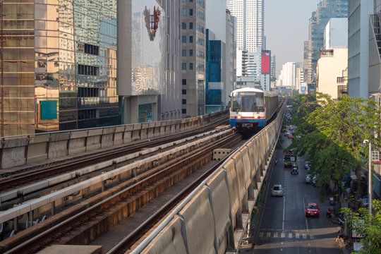 Modern electric trains among the commercial building in the business district, viewed from the platform