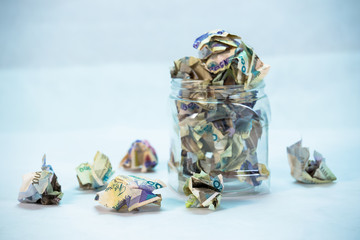Crumpled naira notes in a glass jar concept of savings