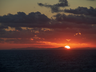Beautiful large Sunset over the mountain with ocean foreground
