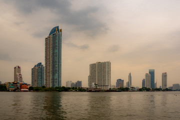 Fototapeta na wymiar Residential , commercial and business buildings next to the river with overcast sunset sky