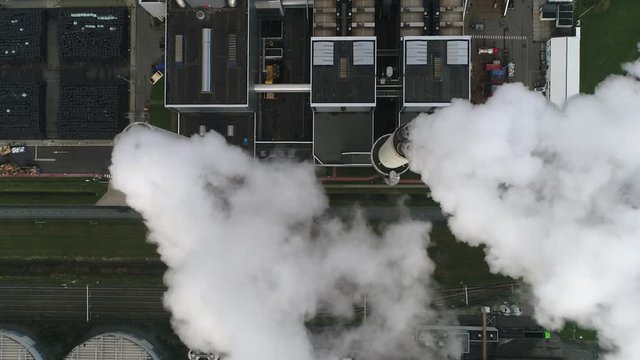 Aerial top down view of coal fired power plant thermal station this electricity production provides about 32 percent of consumed electricity in the United States showing thick white flue exhaust 4k
