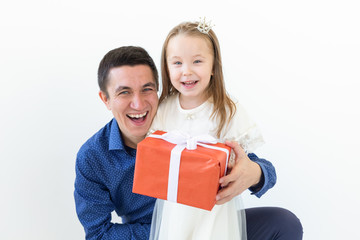peopel, fatherhood and family concept - happy dad holding a gift box with his daughter on white background