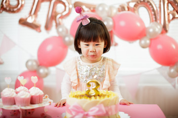 Obraz na płótnie Canvas toddler girl celebrating her third birthday at home