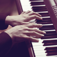 Hands of a musician playing a synthesizer closeup